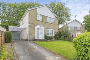 A two-story house with a front garage, a small front yard, and a well-maintained garden. - 4 Bed in Ilkley (oc-ds168) (Ilkley)