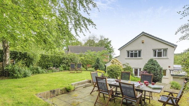 A two-story house with a well-maintained garden, a patio with a table and chairs, and a small shed. - 4 Bed in Ilkley (oc-ds168) (Ilkley)
