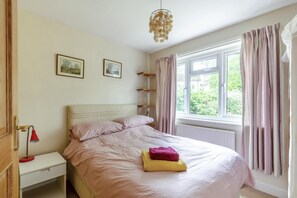 A bedroom with a bed, a nightstand, a lamp, a window with curtains, and a wall-mounted shelf. - 4 Bed in Ilkley (oc-ds168) (Ilkley)