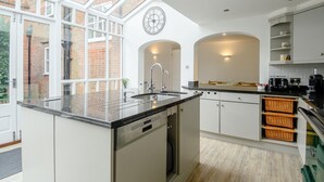 A modern kitchen with a large island, white cabinetry, and a skylight. - 5 Bed in Southwold (oc-tomill) (Southwold)