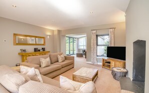 A spacious living room with a sofa set, a television, and a fireplace. - 5 Bed in Catsash (oc-u32331) (Newport)