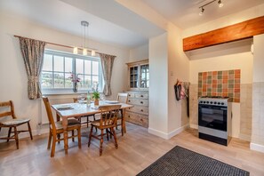 Eine moderne Küche mit einem Holzespeisetisch, Stühlen und einem eingebauten Backofen.