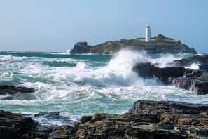 Eine felsige Küste mit einem Leuchtturm auf einer kleinen Insel.