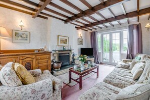 A traditional living room with a fireplace, sofas, and a television. - 3 Bed in Goathland (oc-c32364) (Woodlands)