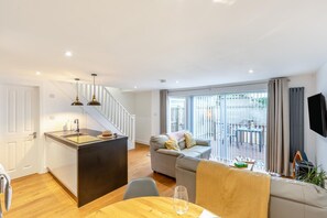 Ein modernes Apartment mit Küche, Essbereich und einem Balkon mit Aussicht.