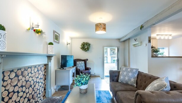 A modern living room with a fireplace, a television, a sofa, and a coffee table. - 2 Bed in Pateley Bridge (oc-ds127) (Castlestead)