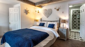 A bedroom with a bed, bedside tables, a wall-mounted light fixture, and a door. - 2 Bed in Pateley Bridge (oc-ds127) (Castlestead)