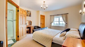 A bedroom with a bed, a desk, a chair, a wardrobe, and a window with curtains. - 5 Bed in Aberystwyth (oc-wan443) (Llanfarian)
