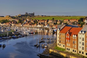 A harbor with boats, a historic building, and residential buildings. - 2 Bed in Whitby (oc-w945) (Whitby)