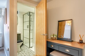 A bathroom with a glass shower enclosure, a wooden vanity with a mirror, and a small plant on the counter. - 2 Bed in Whitby (oc-h32509) (Whitby)