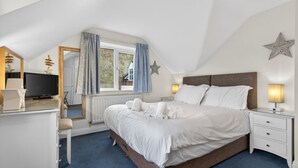 A bedroom with a bed, bedside tables, a desk, a television, and a window with curtains. - 2 Bed in Whitby (oc-w793) (Whitby)