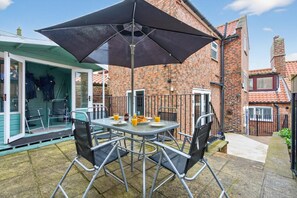 An outdoor patio with a table, chairs, and a large umbrella. - 2 Bed in Whitby (oc-w793) (Whitby)