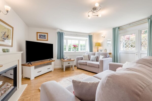 Een woonkamer met een televisie, bank en een open haard.