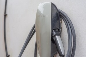 Une borne de recharge Tesla avec un câble branché.