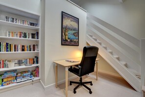 Un bureau à domicile comprenant un bureau, une chaise, une bibliothèque et un escalier.