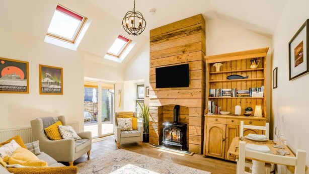A cozy living room with a fireplace, a television, and a bookshelf. - 1 Bed in Lowick (oc-gd1892) (Lowick)