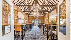 A restaurant with brick walls, a checkered floor, and a chandelier. Tables and chairs are arranged for dining. - 1 Bed in Northrepps (oc-f32556) (Cromer)
