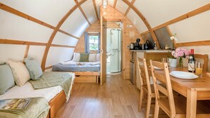 A cozy attic room with a bed, a dining table with chairs, a kitchen area, and a shower. - 1 Bed in Northrepps (oc-f32558) (Cromer)
