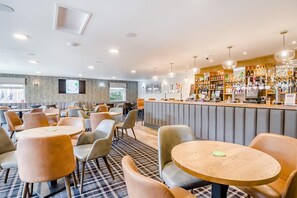 A modern bar area with seating, a bar counter, and a variety of bottles. - 1 Bed in Northrepps (oc-f32559) (Cromer)