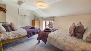 A bedroom with two beds, a wooden dresser, a window with a view, and a ceiling light fixture. - 2 Bed in Sedgeford (oc-2121) (Sedgeford)