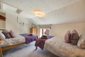 A bedroom with two beds, a wooden dresser, a window with a view, and a ceiling light fixture. - 2 Bed in Sedgeford (oc-2121) (Sedgeford)
