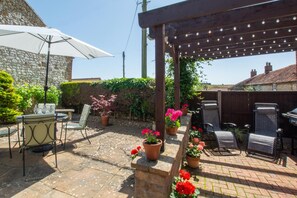 A patio area with a pergola, outdoor seating, and potted plants. - 2 Bed in Sedgeford (oc-2121) (Sedgeford)