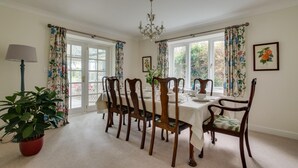 A dining room with a table set for four, surrounded by wooden chairs. - 3 Bed in Cley (oc-2122) (Cley next the Sea)