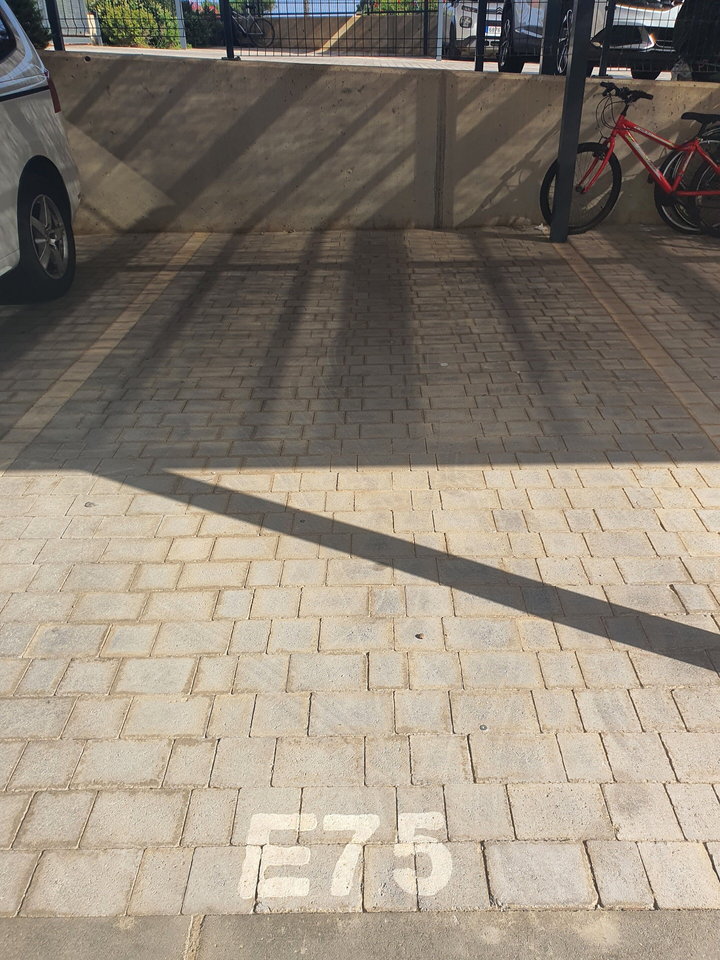 Une zone pavée avec un vélo et une voiture.