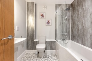 A bathroom with a toilet, sink, and shower.