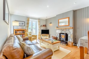 A cozy living room with a sofa, a television, a fireplace, and a bookshelf. - 1 Bed in Newtonmore (oc-a32412) (Newtonmore)