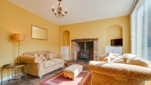 A living room with a fireplace, sofas, a coffee table, and a TV. - 2 Bed in Eye (oc-4lamb) (Eye)