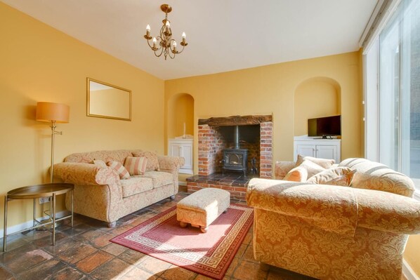 A living room with a fireplace, sofas, a coffee table, and a TV. - 2 Bed in Eye (oc-4lamb) (Eye)