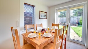 A dining area with a wooden table set for breakfast, including plates, bowls, and glasses of orange juice. - 3 Bed in Whitby (oc-w943) (Whitby)