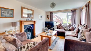 A cozy living room with a fireplace, a television, and comfortable seating. - 3 Bed in Whitby (oc-w943) (Whitby)