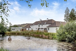 A residential area with houses, a pond, and a wooden fence. - 1 Bed in Newtonmore (oc-l32415) (Newtonmore)