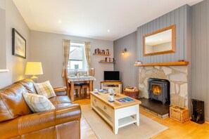 A cozy living room with a fireplace, a sofa, a coffee table, and a television. - 1 Bed in Newtonmore (oc-l32415) (Newtonmore)