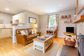 A cozy living room with a sofa, coffee table, and fireplace. - 1 Bed in Newtonmore (oc-l32415) (Newtonmore)