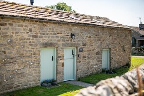 En byggnad av sten med två ljusgröna dörrar och en skylt med texten ”Bryggeriets badhus”.