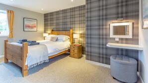 A bedroom with a bed, bedside tables, a mirror, and a small stool. - 1 Bed in Newtonmore (oc-b32417) (Newtonmore)