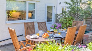 An outdoor dining area with a round table, wooden chairs, and a variety of breakfast items. - 5 Bed in Runswick Bay (oc-wa817) (Runswick Bay)