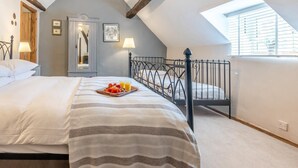 Ein Schlafzimmer mit einem Bett, einer Obst- und Safttablett, einem Spiegel und einem Dachfenster.