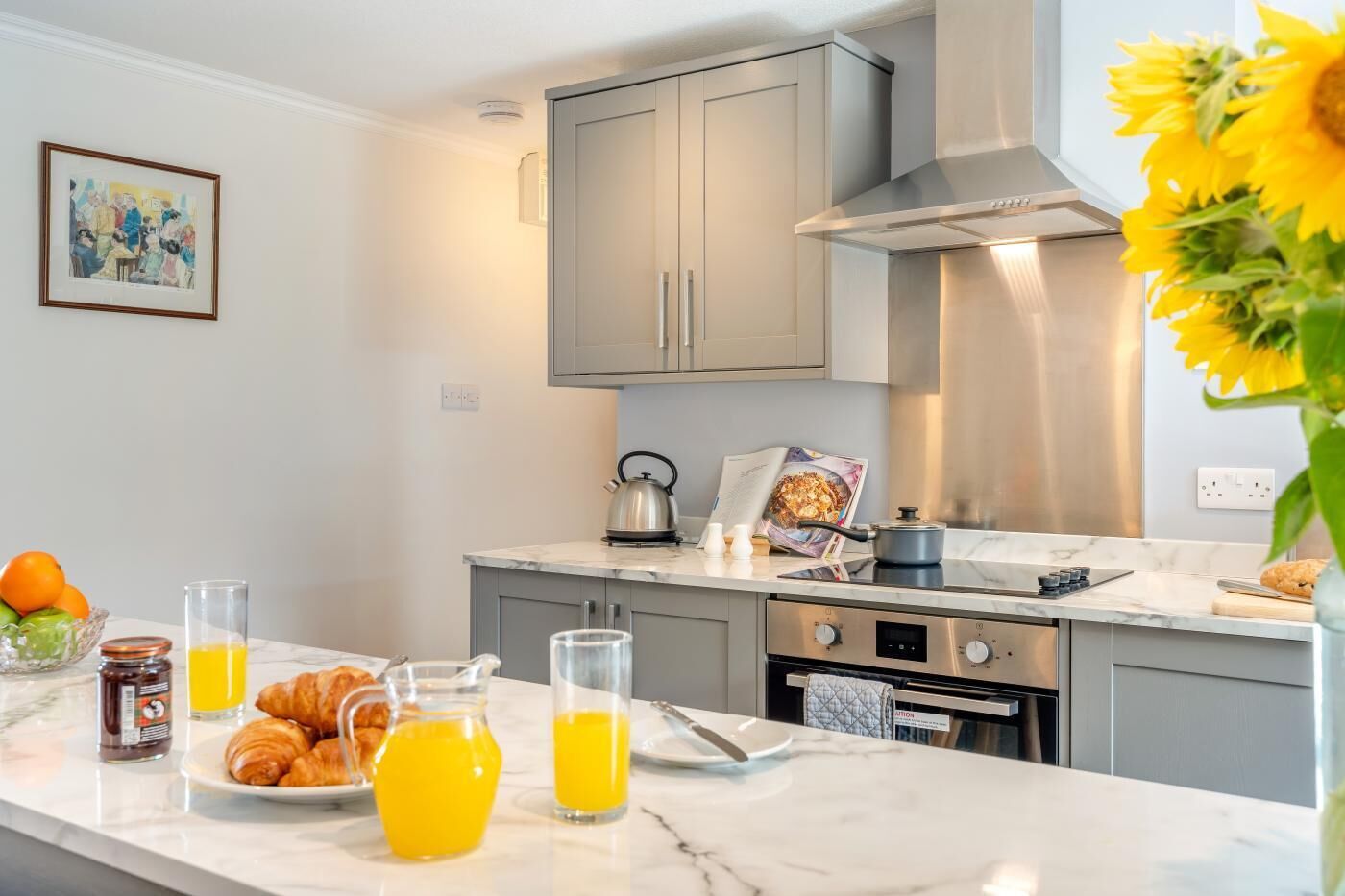 A modern kitchen with a marble countertop, stainless steel appliances, and a visible oven.