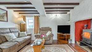 A cozy living room with a fireplace, leather sofas, a TV, and a wooden coffee table. - 2 Bed in Yatton (oc-s32603) (Leinthall Earls)