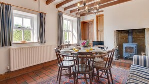 Un coin repas chaleureux avec une table en bois, des chaises et une cheminée.