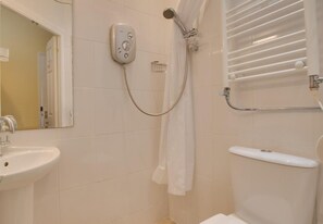 Ein Badezimmer mit Dusche, Waschbecken und Handtuchhalter.