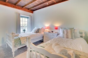 A bedroom with two beds, a window with curtains, a bedside table with lamps, and a wooden ceiling. - 2 Bed in Whitby (oc-wa032) (Grosmont)