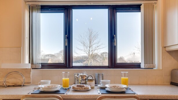A breakfast setup with a table, chairs, and a window view. - 1 Bed in Chesterfield (oc-dcelm) (England)