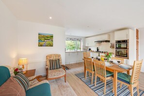 Eine moderne Wohnung mit Wohnzimmer, Essbereich und Küche.