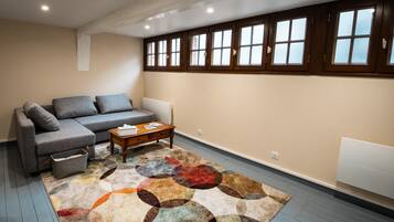 A living room with a sofa, coffee table, and a patterned rug.