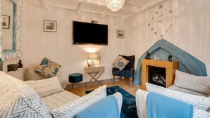 Ein Wohnzimmer mit Kamin, Fernseher und einer Wanduhr.